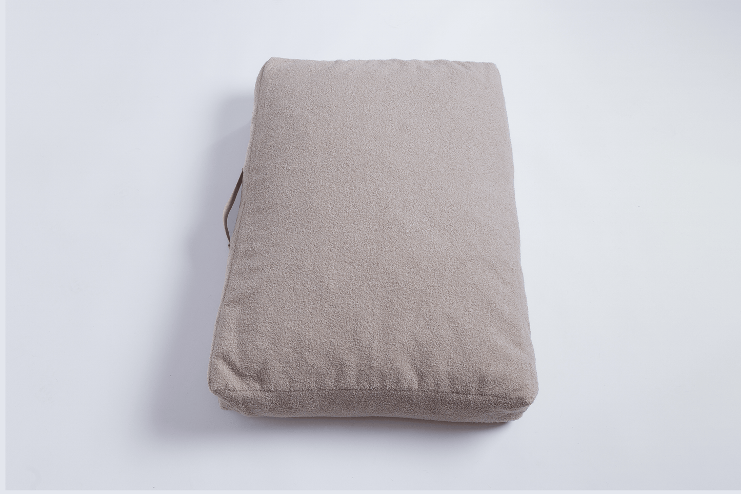 orthopädisches hundebett in beige Teddyfell von der Seite mit Haltegriff